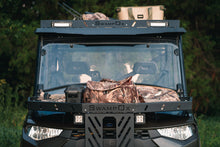 Load image into Gallery viewer, Direct front view of UTV featuring Swamp Ox hood rack, roof rack, and bed racks in grassy outdoor field. Black textured powder-coated racks all carrying outdoor gear.