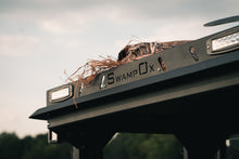 Load image into Gallery viewer, Angled closeup view of UTV featuring Swamp Ox roof rack in outdoor setting during the day. Black textured powder-coated hood rack carrying outdoor gear, including lights, unlit.