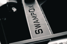 Load image into Gallery viewer, Closeup of SwampOx logo cut out of aluminum rack material.
