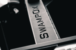 Closeup of SwampOx logo cut out of aluminum rack material.