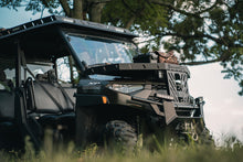 Load image into Gallery viewer, Angled front view of UTV featuring Swamp Ox hood rack, roof rack, and bed racks in grassy outdoor field. Black textured powder-coated racks all carrying outdoor gear.
