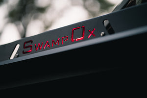 Closeup from lower right of red backlit Swamp Ox logo on roof rack.