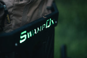 Closeup from above of green backlit Swamp Ox logo on front hood rack.